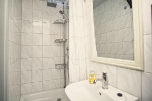 a white bathroom with a sink and a shower at Dünenchalet Nr 49 in Göhren +15 photos