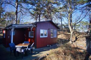 a red tiny house with a table and chairs at Dünenchalet Nr 49 in Göhren