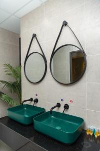 a bathroom with a green sink and a mirror at Oceanus Oasis Retreat Muong Thanh Vien Trieu in Nha Trang