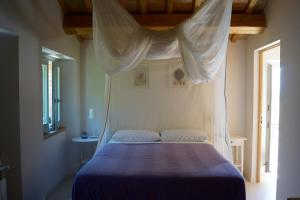 a bedroom with a bed with a canopy at La Giravolta Country House in Barchi +49 photos