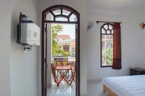 una camera con letto e vista su un balcone di Bống House Homestay 1 a Hoi An