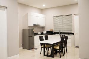 a kitchen with a table and chairs and a refrigerator at so happy pool villa hua hin in Ban Bo Fai