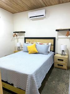 1 dormitorio con 1 cama con almohadas azules y amarillas en Casa Buena Karma, en Ojochal