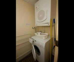 a laundry room with a washing machine and a microwave at Beachpoint, Unit 401, 28 North Street in Forster