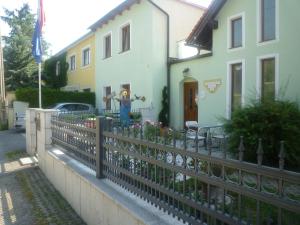una recinzione di fronte a una casa con fiori di Gartenpension Prosl a Vienna