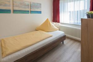 ノルトダイヒにあるFerienhaus Strandlustのベッド(枕付)が備わる客室です。