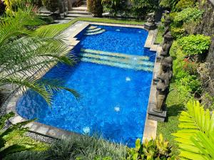 a swimming pool with blue water in a yard at Wahyu Accomodation in Ubud