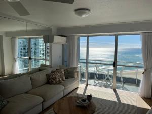 a living room with a couch and a view of the ocean at Endless Summer in Cooly Level 18 in Gold Coast