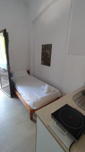 a small room with a bed and a stove in it at Perix House in Neos Marmaras