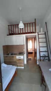 Zimmer mit einem Bett, einem Waschbecken und einer Treppe in der Unterkunft Perix House in Neos Marmaras