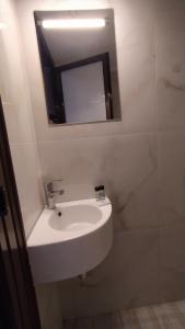 ein Badezimmer mit einem weißen Waschbecken und einem Spiegel in der Unterkunft Perix House in Neos Marmaras