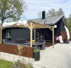 a pavilion with a table and chairs on a patio at Nice holiday home with outdoor pool in Lottorp, Oland in Löttorp