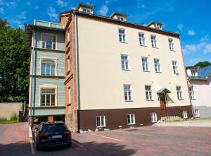 un bâtiment avec une voiture garée devant lui dans l'établissement Lossi 32 Cozy Apartment, à Tartu
