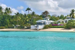 ein Haus am Strand mit blauem Wasser in der Unterkunft Westshore Beach House by Blue Sky Luxury in Saint James