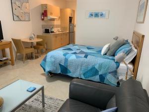 a bedroom with a bed and a living room at Pelicans Rest Shellharbour in Shellharbour