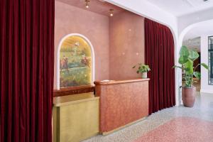 a courtroom with red curtains and a podium with a painting at Hotel Genevieve in Louisville