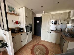 a kitchen with white cabinets and a counter top at Cabane des Flamants YourHostHelper in Gruissan