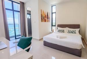 a bedroom with a bed and a desk with a laptop at The Shore - Casa Kinabalu in Kota Kinabalu