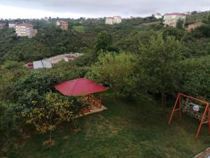 a red umbrella sitting on top of a hill at Adam Garden in Trabzon