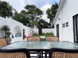 a patio with a glass table and chairs at Arau House in Arau