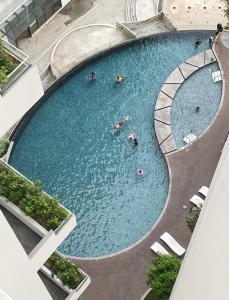 een uitzicht over een zwembad met mensen erin bij The Shore - Casa Kinabalu in Kota Kinabalu