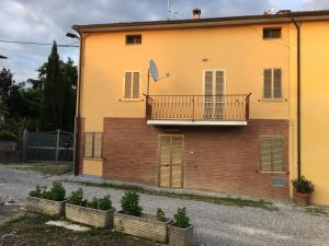 - un bâtiment avec un balcon sur le côté dans l'établissement Casa RODA Umbria 1Km da Toscana, à Castiglione del Lago
