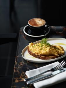 een tafel met twee borden eten en een kop koffie bij A by Adina Canberra in Canberra