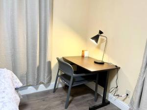 a desk with a lamp and a chair next to a bed at Warm 2BR/1BA house Silicon W/D parkin near SJ town in San Jose