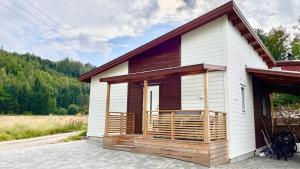 Cette petite maison blanche dispose d'une terrasse couverte. dans l'établissement Holiday Home Ljungskile, à Ljungskile
