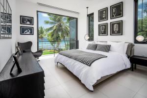 a white bedroom with a large bed and a window at Onyx by Blue Sky Luxury in Saint James