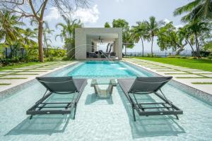 a swimming pool with two chairs and a table at Onyx by Blue Sky Luxury in Saint James