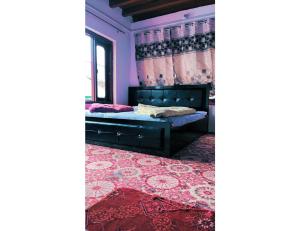 a bedroom with a bed and a red rug at Hotel Dayban Resort, Pahalgam in Pahalgām