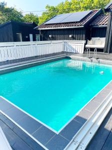 a swimming pool with blue water and a white fence at Brightside Apartment in Kristiansand