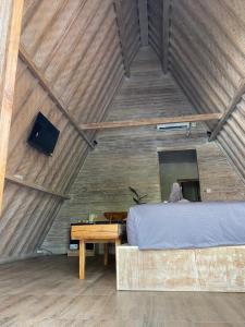 1 dormitorio con 1 cama, escritorio y TV en Kuri Garden Cottage, en Nusa Penida