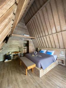 ein Schlafzimmer mit einem großen Bett und einer Holzdecke in der Unterkunft Kuri Garden Cottage in Nusa Penida