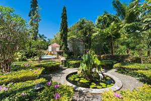 ein Garten mit Blumen und einem Teich in der Unterkunft Porters Villa by Blue Sky Luxury in Saint James + 11 Fotos