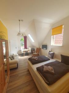 a bedroom with two beds and a living room at Twee Linden Warnemünde Zentrum in Warnemünde