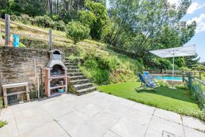 patio z grillem, krzesłem i basenem w obiekcie Casa Davide With Pool - Happy Rentals w mieście Pietrasanta