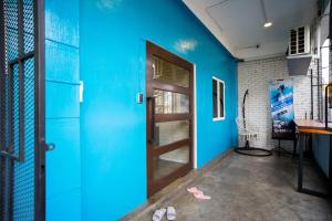 a room with a blue wall and a door at Buddy Station in Semporna