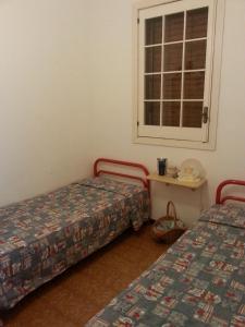 Zimmer mit 2 Betten und einem Tisch mit Fenster in der Unterkunft Villetta Via Fregene in Marina di Ragusa