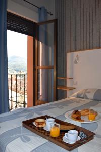 a tray with pancakes and orange juice on a bed at Hostal Altamira Guadalupe in Guadalupe