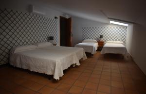 a bedroom with two beds and a window at Hostal Altamira Guadalupe in Guadalupe