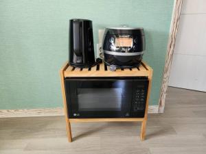 a microwave with a coffee maker on top of it at Doldamine Jeju in Jeju