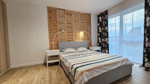a bedroom with a bed and a large window at Crinului 12 MS in Târgu-Mureş