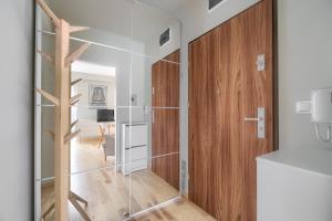 une chambre avec une porte coulissante en verre et un salon dans l'établissement Gąsiorowskich Beige Apartment, à Poznań