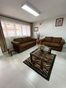 a living room with two couches and a coffee table at Imbasa House - Arusha in Arusha