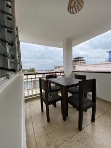 a table and chairs on a balcony with a view at Imbasa House - Arusha in Arusha