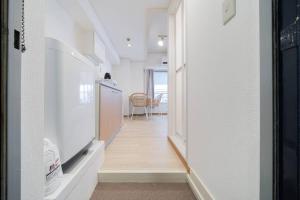 a hallway leading to a kitchen with a table at Takadanobaba Address102 in Tokyo
