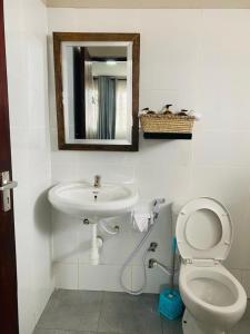 a bathroom with a sink and a toilet and a mirror at Imbasa House - Arusha in Arusha