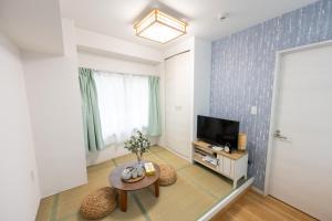 a living room with a tv and a table at 今和Hotel in Tokyo